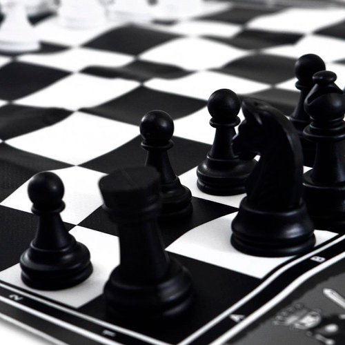 Fotografia em preto e branco de peças sobre um tabuleiro de xadrez
